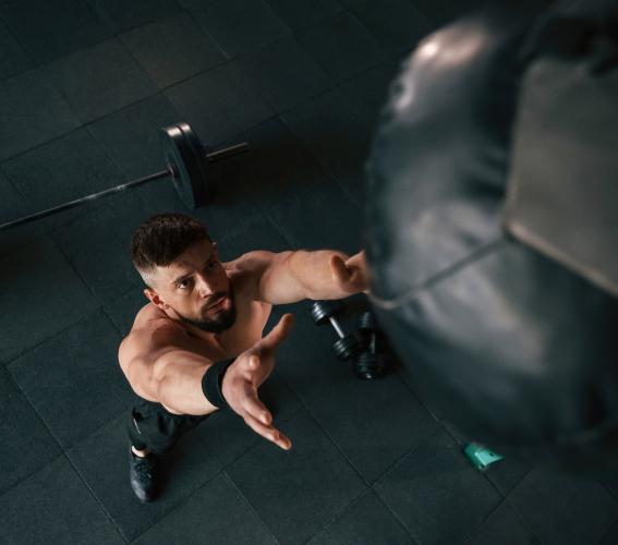 Homme réalisant un exercice de musculation avec haltères dans une salle de sport